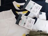 several pairs of men ' s t - shirts are laid out on a bed