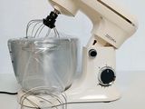 a white mixer with a whisk and a bowl on the table