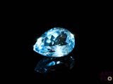 a close up of a blue diamond on a black surface