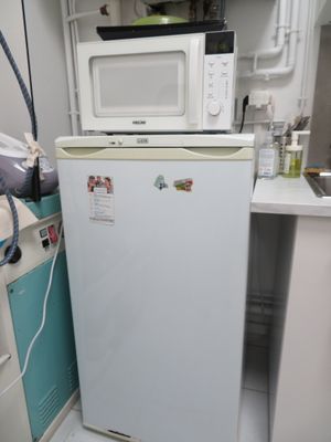 un petit réfrigérateur blanc dans le coin d'une cuisine