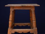an old wooden stool against a dark blue background