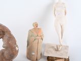 three statues of a man and a woman on a table