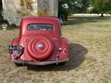 a red car that is parked in the grass