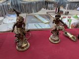 trois figurines posées sur une table recouverte d'une nappe rouge