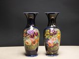deux vases posés sur une table, sur lesquels sont peints des fleurs