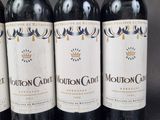 four bottles of wine are lined up on a table