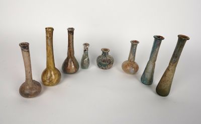 Plusieurs vases sont disposés en rangée sur une surface blanche