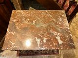 a marble table with a wooden chair in the background