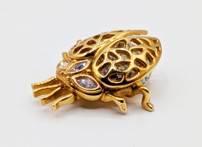 an image of a gold turtle broochle on a white surface