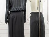 two mannequins in front of a white wall and a black dress on a mannequin stand