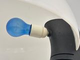 a black and white toilet with a blue light bulb in it