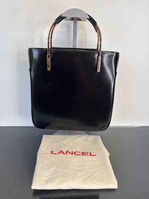 an image of a black handbag sitting on top of a table