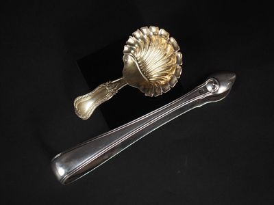 une cuillère en argent et une cuillère en argent posées sur une surface noire