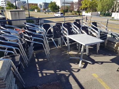 a lot of chairs and tables in a parking lot