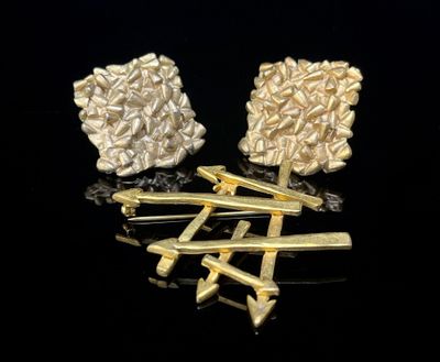 deux paires de boucles d'oreilles en or et en argent sur un fond noir
