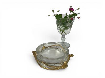 a glass vase with a flower in it on a plate