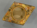 a small gold plate with a flower design on it
