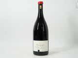 une bouteille de vin rouge posée sur une table blanche