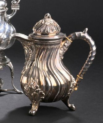 une cafetière en argent et une théière en argent posées sur un support