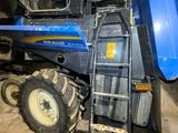 a blue tractor that is parked in the dirt
