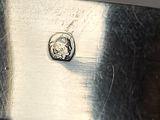 a silver plate with a horse on it on a table