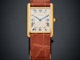 une montre Cartier Tank en or jaune 18 carats avec un bracelet en cuir marron