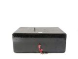 a black metal box with a red handle and a key in it