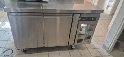 a stainless steel kitchen island with a microwave on top of it
