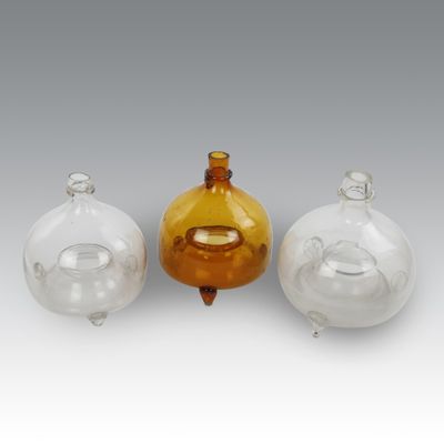 three glass vases sitting next to each other on top of a table