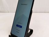 a close up of a phone on a stand on a white surface
