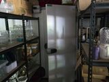 un réfrigérateur au milieu d'une pièce comportant de nombreuses étagères