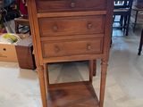 a wooden table with a drawer on it in a room
