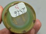 a person holding a small green object with a tag on it