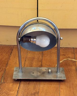 une lampe posée sur le sol à côté d'un mur