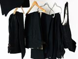 beaucoup de vêtements noirs suspendus à un portant