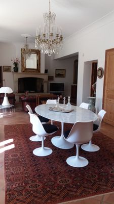 a table and chairs in a living room with a chandelier