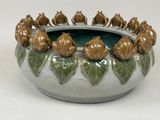 a close up of a ceramic bowl with a bunch of figurines in it