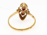 a close up of a gold ring with a red stone in the center