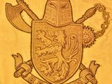 yellow t - shirt with a crest and two crossed axes on it