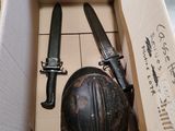 une boîte contenant deux couteaux et un casque