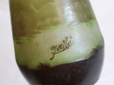 a green vase with a name on it sitting on a table