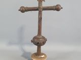 une croix en bois posée sur un socle, surmontée d'une croix en métal