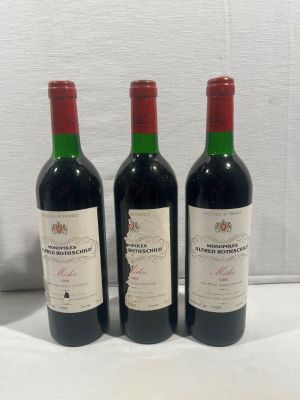 trois bouteilles de vin posées sur une table blanche