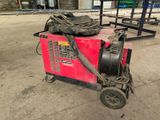 a red machine that is sitting in the middle of a parking lot
