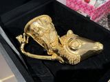 a gold figurine of a mouse in a black box