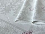 deux serviettes pliées sur un lit orné d'une couronne