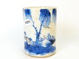 une tasse bleue et blanche sur laquelle est représenté un arbre