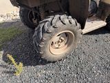 un petit quad équipé de gros pneus, garé sur un terrain en gravier