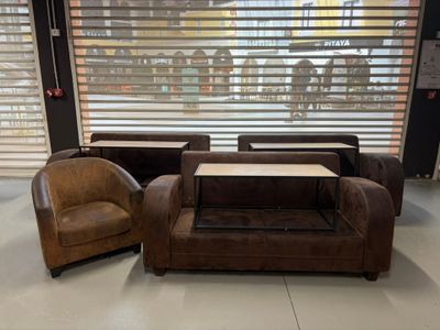 plusieurs chaises et une table dans une pièce, avec une fenêtre derrière elles