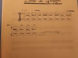 a sheet of music on a table with a pen in it